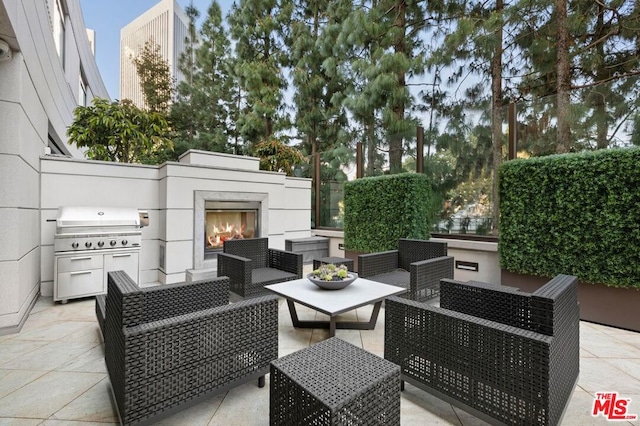 view of patio featuring an outdoor living space with a fireplace and an outdoor kitchen