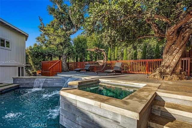 view of pool with an in ground hot tub, pool water feature, and a deck