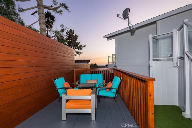 deck at dusk featuring outdoor lounge area