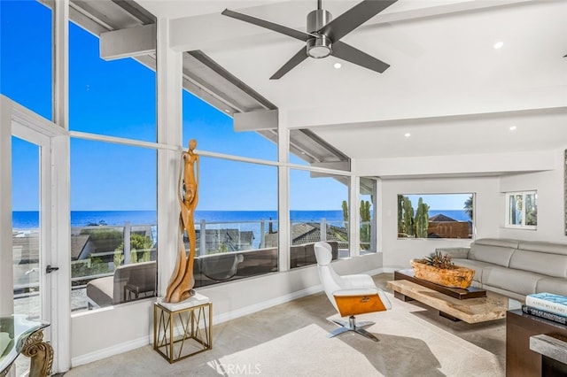 sunroom with lofted ceiling with beams, a water view, and ceiling fan