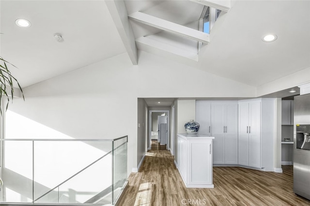 hall with beam ceiling, high vaulted ceiling, and light wood-type flooring