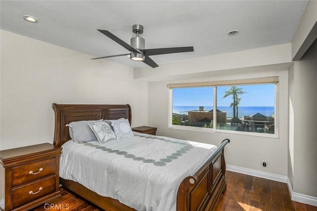 bedroom with a water view, ceiling fan, and dark hardwood / wood-style floors