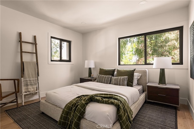 bedroom featuring hardwood / wood-style flooring and multiple windows