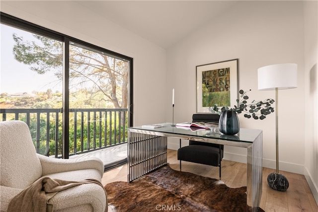 home office with vaulted ceiling and hardwood / wood-style flooring