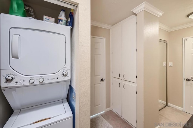 clothes washing area with ornamental molding and stacked washer and clothes dryer