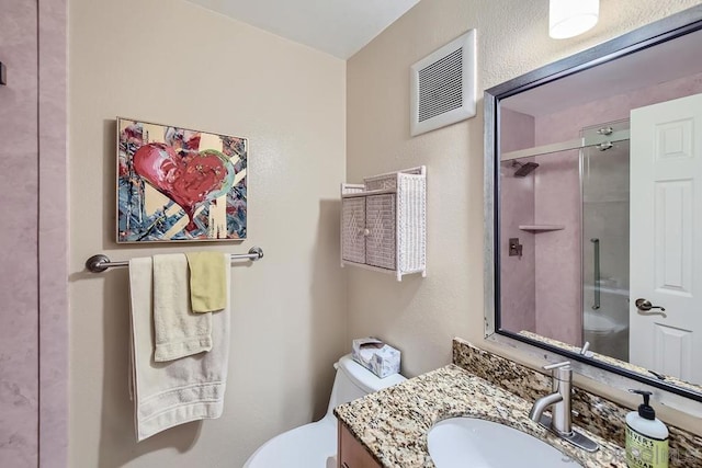 bathroom featuring vanity, toilet, and an enclosed shower