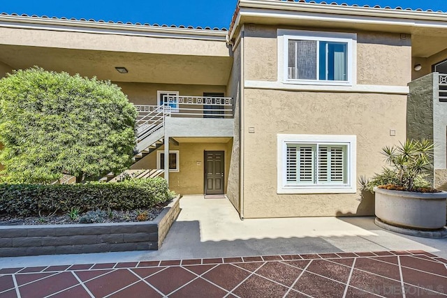 view of exterior entry with a patio and a balcony