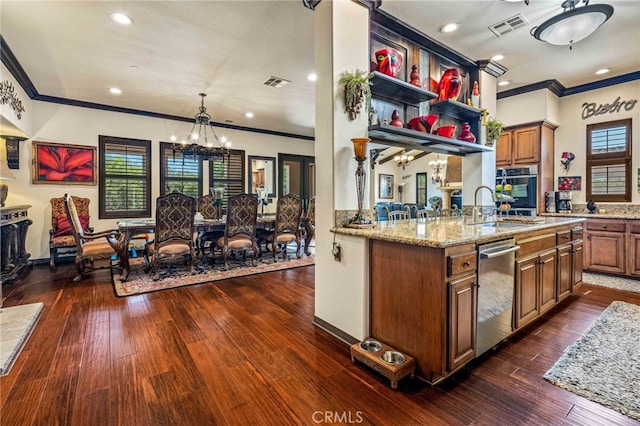 kitchen with stainless steel appliances, brown cabinets, a notable chandelier, and visible vents