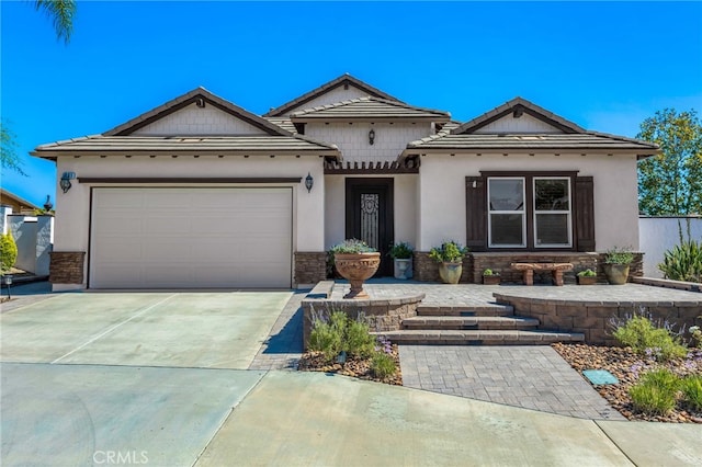 view of front of home featuring stucco siding, concrete driveway, an attached garage, and a tiled roof