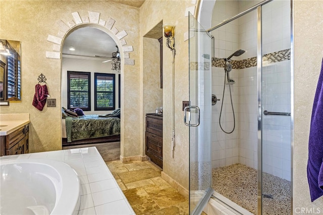 ensuite bathroom featuring a shower stall, ensuite bathroom, a bath, vanity, and a ceiling fan