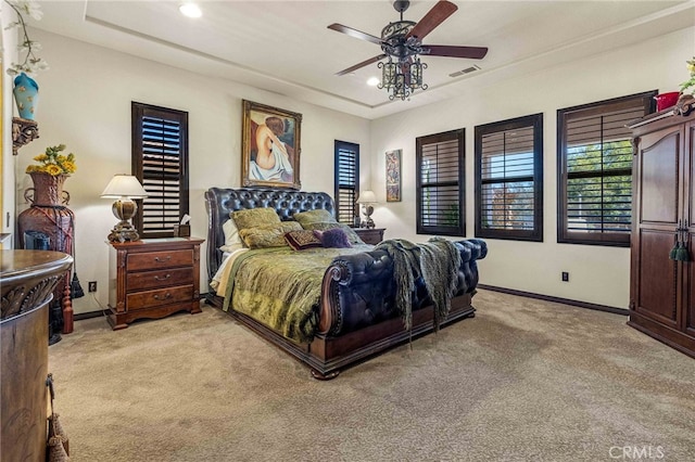 bedroom featuring visible vents, baseboards, a tray ceiling, light carpet, and recessed lighting