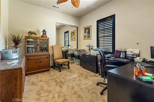 carpeted office with visible vents and a ceiling fan