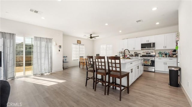 kitchen featuring ceiling fan, appliances with stainless steel finishes, white cabinetry, and sink