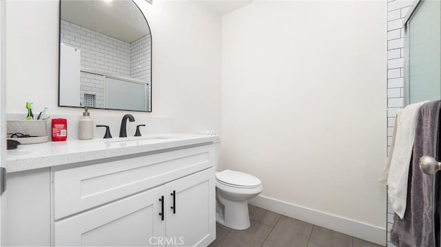 bathroom featuring a shower with door, tile patterned floors, toilet, and vanity