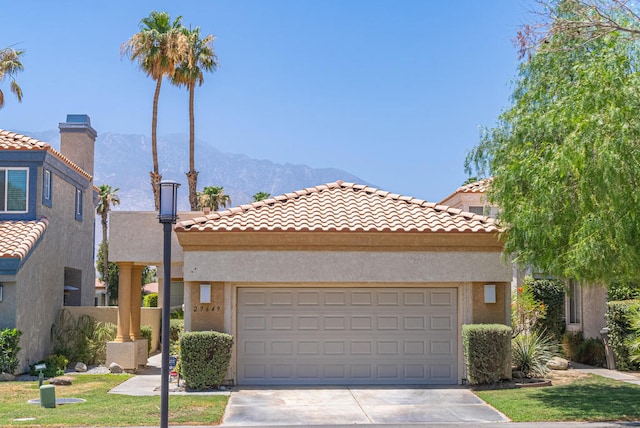 mediterranean / spanish home featuring a mountain view, a front yard, and a garage