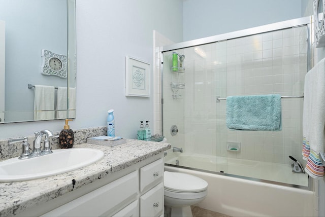 full bathroom featuring vanity, bath / shower combo with glass door, and toilet