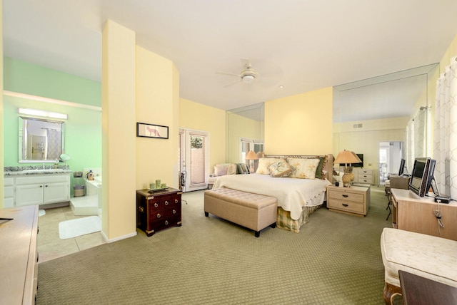 bedroom with connected bathroom, ceiling fan, and light colored carpet