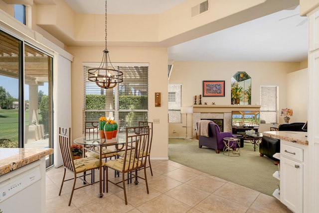 carpeted dining area with an inviting chandelier