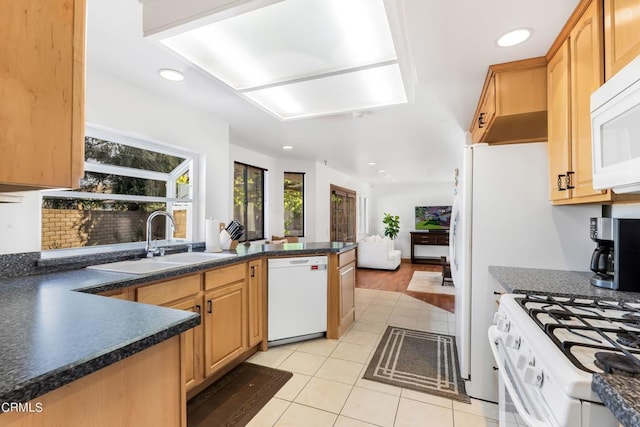 kitchen featuring light brown cabinetry, white appliances, sink, and light tile patterned floors