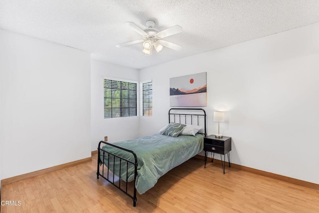 bedroom featuring ceiling fan, hardwood / wood-style floors, and a textured ceiling