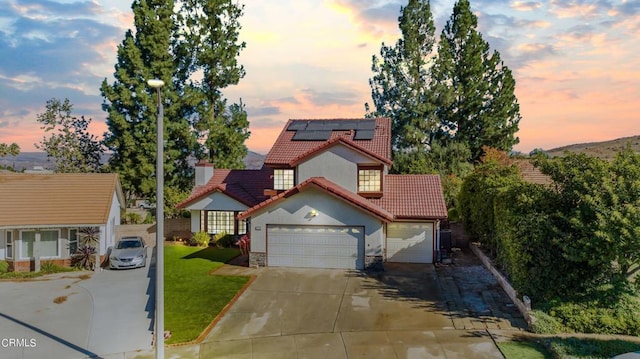 view of front of property featuring central AC unit, solar panels, and a yard