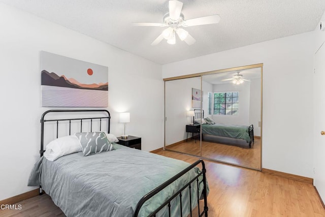 bedroom with ceiling fan, a closet, hardwood / wood-style floors, and a textured ceiling