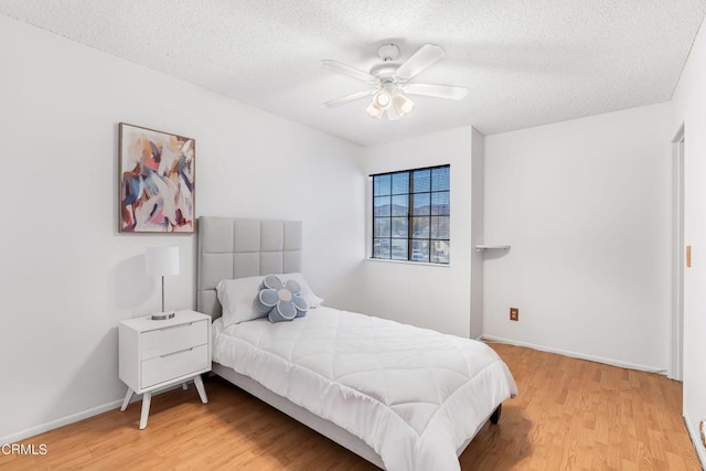 bedroom featuring ceiling fan, a textured ceiling, and hardwood / wood-style flooring