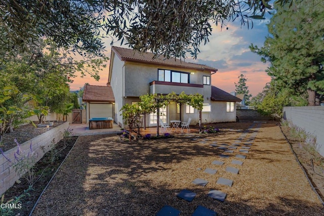 back house at dusk with a patio area