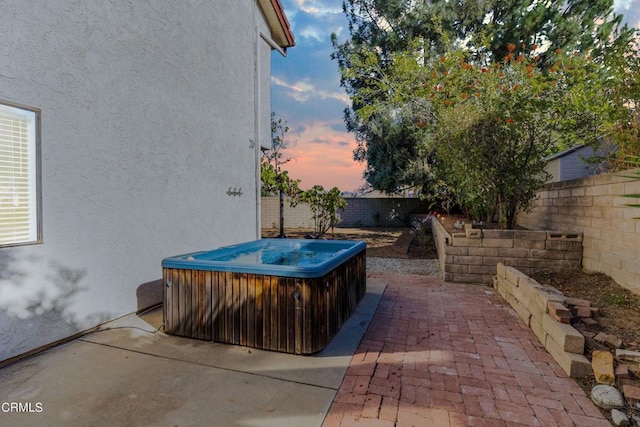 patio terrace at dusk with a hot tub