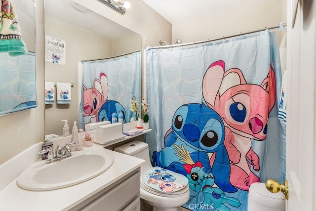 bathroom with vanity, toilet, and walk in shower