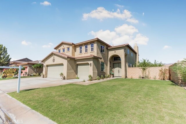 mediterranean / spanish home featuring a front yard and a garage