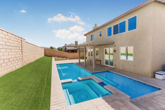 view of swimming pool with a patio, pool water feature, an in ground hot tub, and a lawn