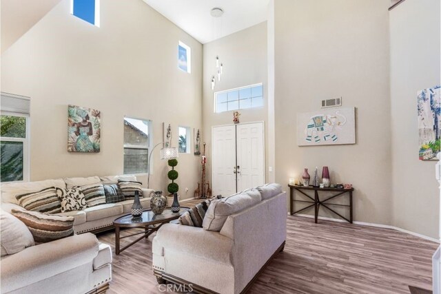 living room featuring high vaulted ceiling and wood-type flooring