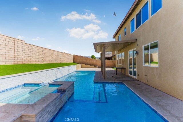 view of pool featuring an in ground hot tub, pool water feature, and a patio area