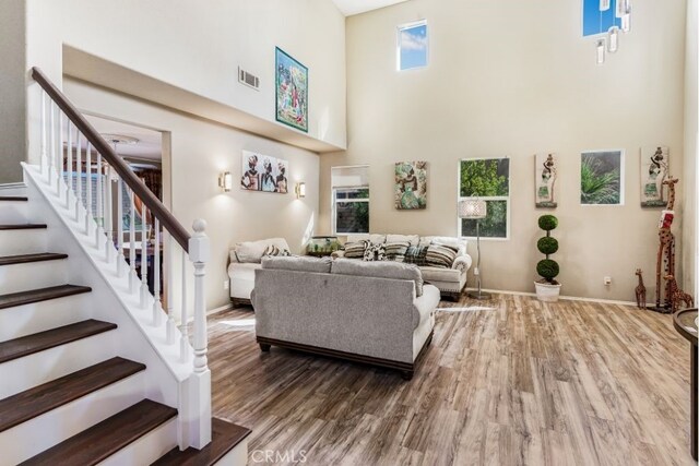 living room with hardwood / wood-style floors and a high ceiling