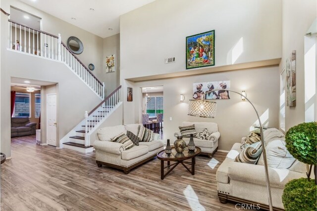 living room with hardwood / wood-style floors and a towering ceiling