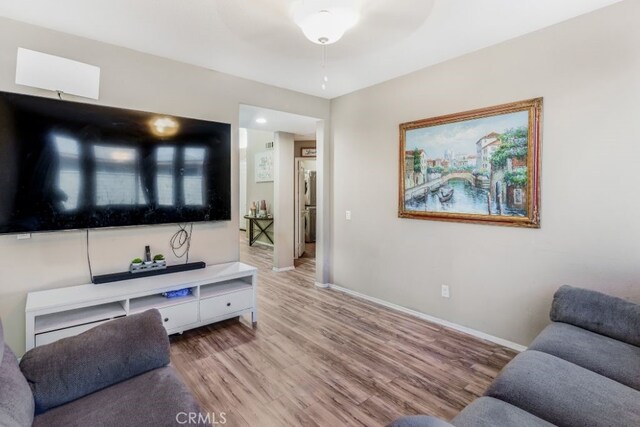 living room featuring ceiling fan and light hardwood / wood-style flooring