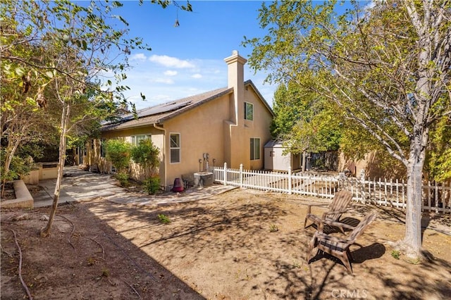 rear view of property with solar panels