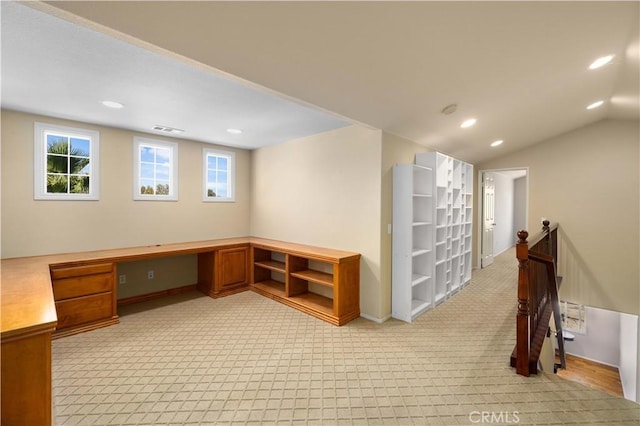 carpeted office space featuring a wealth of natural light, built in desk, and lofted ceiling