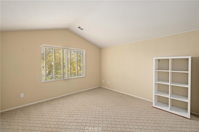 carpeted empty room featuring lofted ceiling