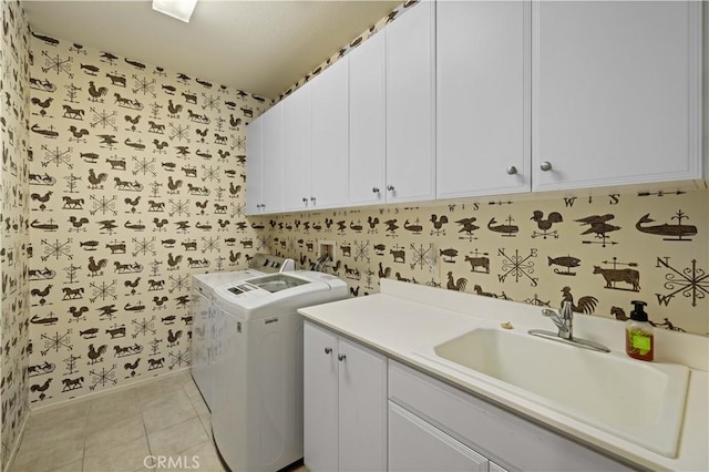 laundry area featuring cabinets, sink, light tile patterned flooring, and washing machine and clothes dryer