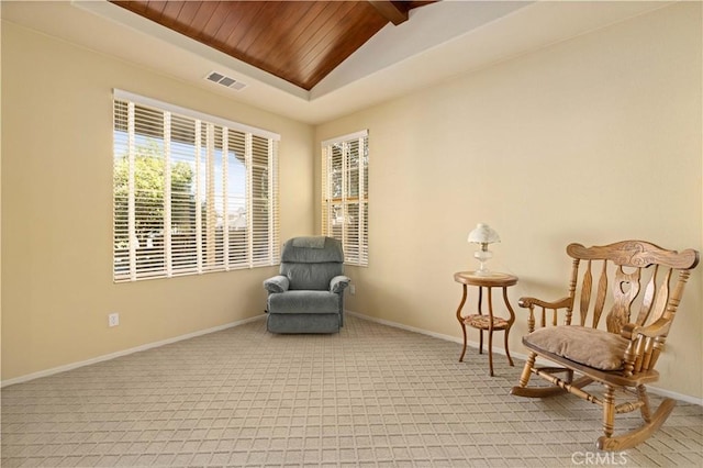 living area with light carpet, lofted ceiling with beams, and wooden ceiling