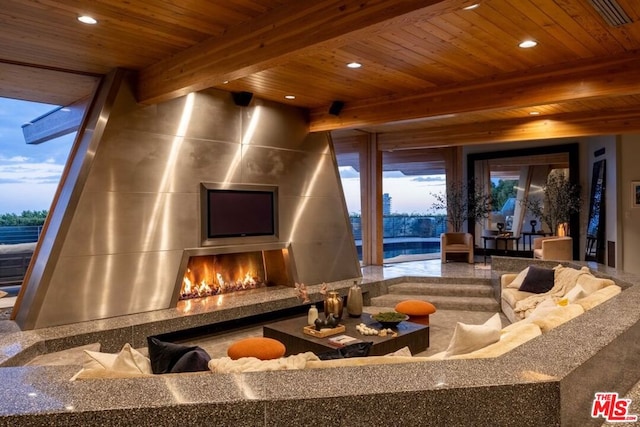 home theater room featuring a fireplace, beam ceiling, a wealth of natural light, and wooden ceiling