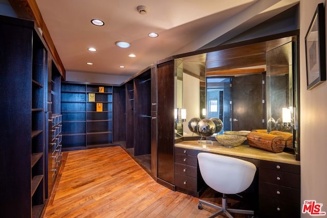 home office with built in desk and light wood-type flooring