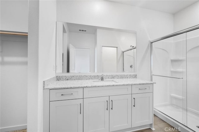 bathroom featuring a shower with door, vanity, and hardwood / wood-style flooring