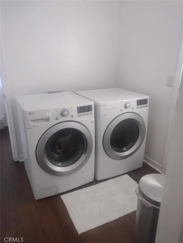 laundry area featuring separate washer and dryer and dark hardwood / wood-style flooring