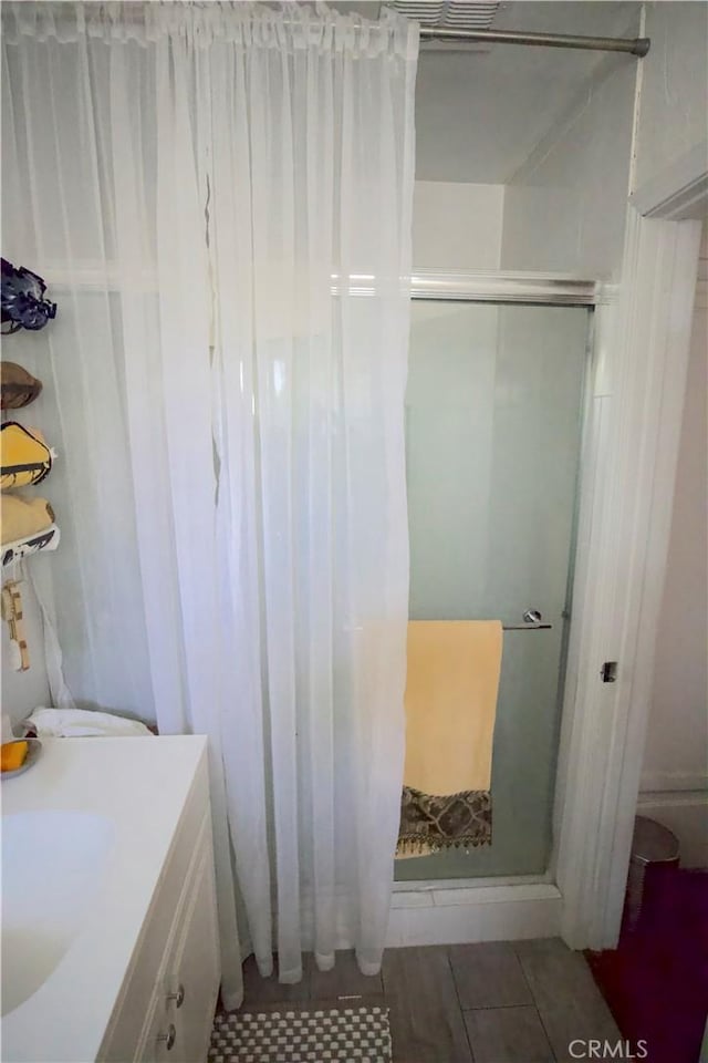 bathroom with tile patterned flooring, vanity, and a shower