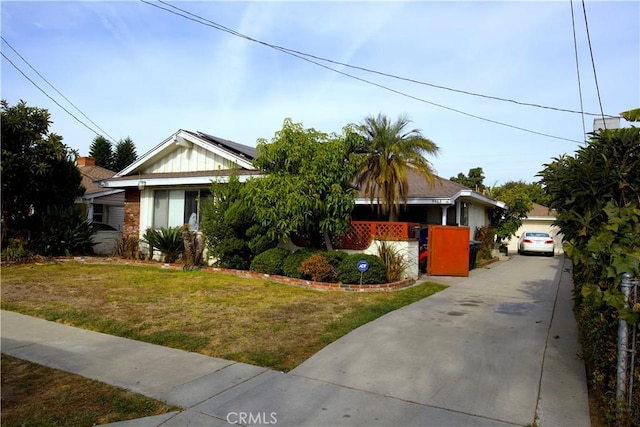 view of front of house with a front lawn and solar panels