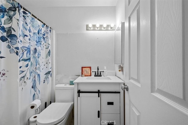 bathroom featuring toilet, vanity, and walk in shower