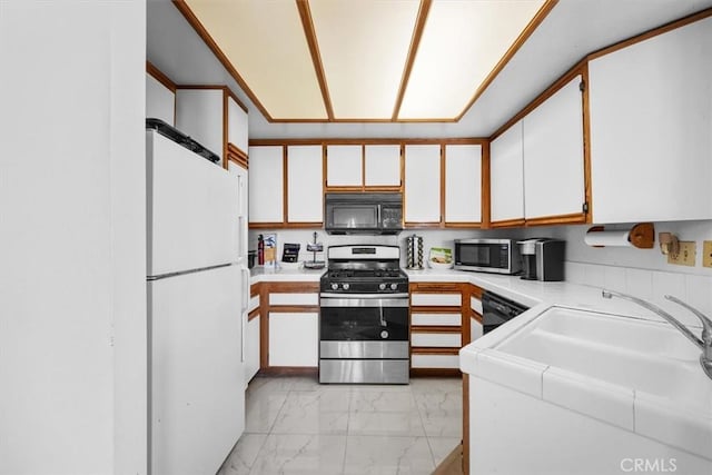 kitchen with white cabinetry, sink, and black appliances